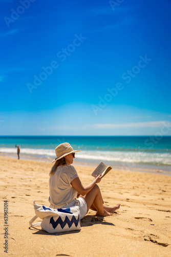 Woman sitting on beach in Alvor, Portugal reading book
#639613014
