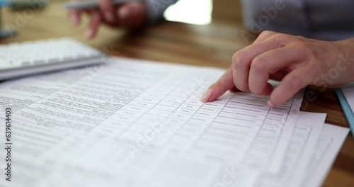 Female accountant uses calculator while calculating taxes for client. Business audit and finance