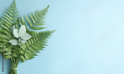 A green fern bouquet on a pastel blue background. Created by generative AI