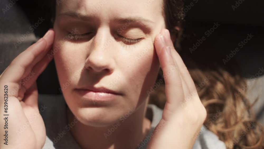 Top view of tired sad young caucasian female lying on couch rubs temple, closed eyes suffers headache painful feelings chronic migraine hurt. Break up and divorce, difficult period of life concept Top view of tired sad young caucasian female lying on couch rubs temple, closed eyes suffers headache painful feelings chronic migraine hurt. Break up and divorce, difficult period of life concept