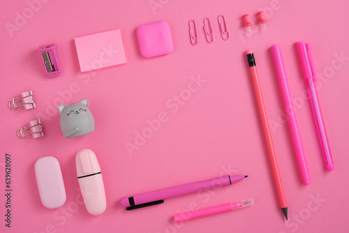 Frame of pink school and office stationery set on pink background. Eraser in the form of cat