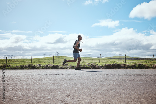 Training, marathon runner and man on road outdoor, cardio or healthy body. Athlete, sport and fitness exercise in competition, workout energy or race on street in wellness at countryside mockup space