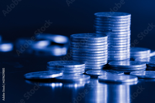 Money coin stack on black background with blue filter. Business and finance background concept.