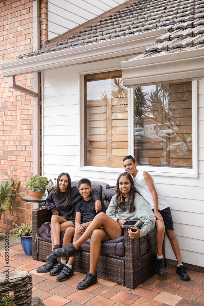 First nations family sitting together on couch outside First nations family sitting together on couch outside