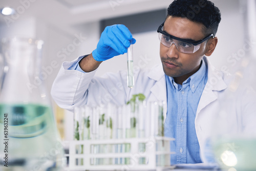 Science, leaves and man with test tube in laboratory, research and thinking with nature. Biotechnology, pharmaceutical study and scientist with plants, lab technician checking green solution in glass
