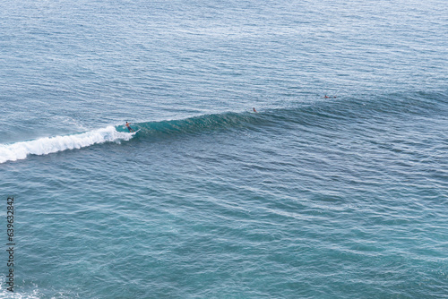 Surfer on wave with an open face at Uluwatu surf spot, Bali, Indonesia