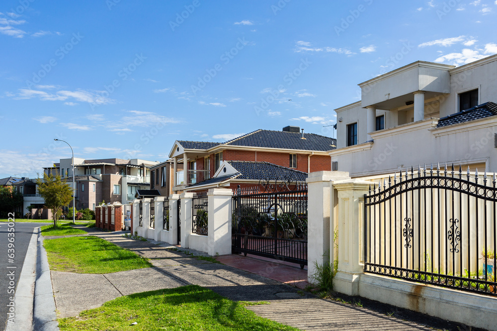 Housing affordability concept showing row of houses with footpath on city street Housing affordability concept showing row of houses with footpath on city street