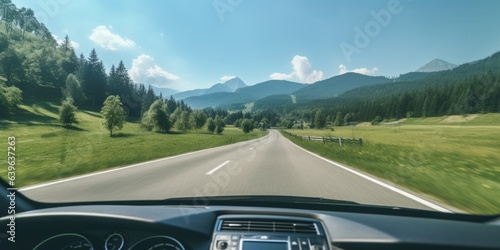 A car driving down a country road with mountains in the background. Digital image.