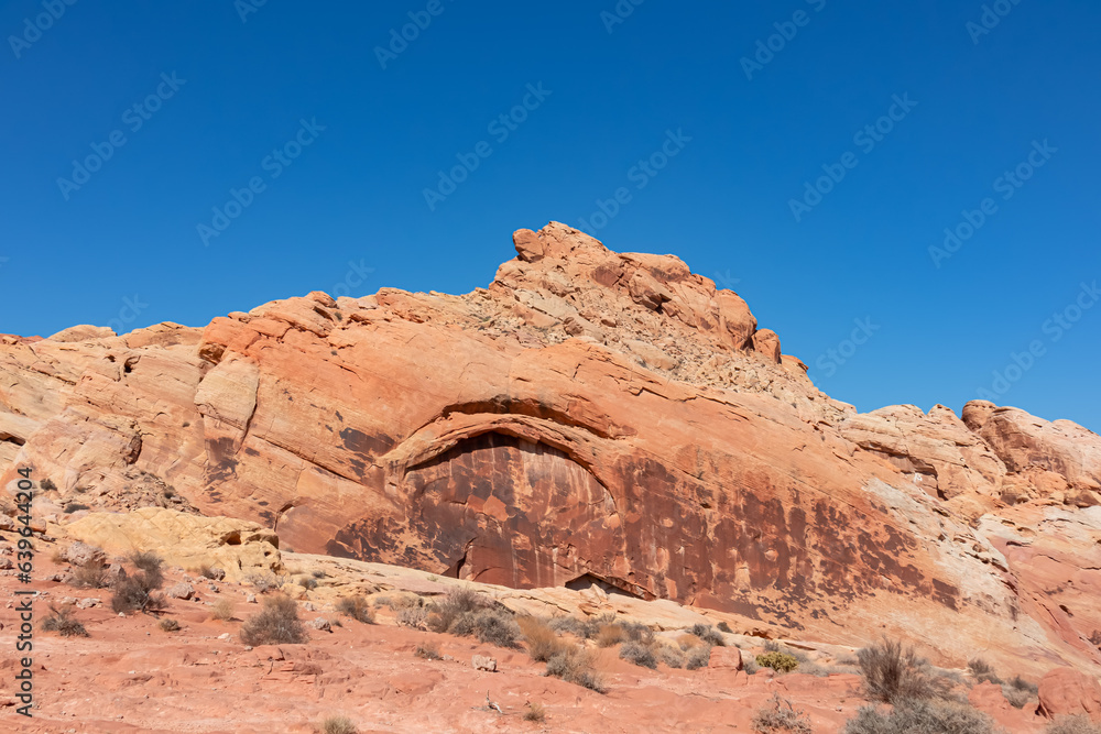 Scenic view of white Aztek sandstone rock formations in Petroglyph Canyon along Mouse Tank hiking trail in Valley of Fire State Park in Mojave desert, Nevada, USA. Hot temperature in arid vegetation