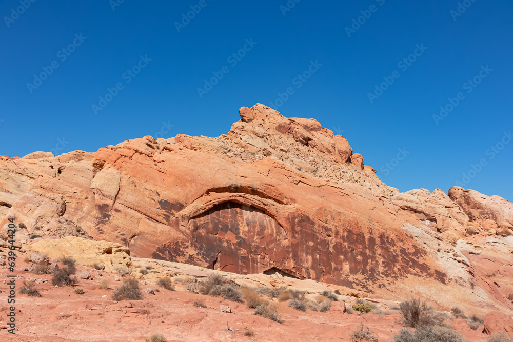 Scenic view of white Aztek sandstone rock formations in Petroglyph Canyon along Mouse Tank hiking trail in Valley of Fire State Park in Mojave desert, Nevada, USA. Hot temperature in arid vegetation Scenic view of white Aztek sandstone rock formations in Petroglyph Canyon along Mouse Tank hiking trail in Valley of Fire State Park in Mojave desert, Nevada, USA. Hot temperature in arid vegetation