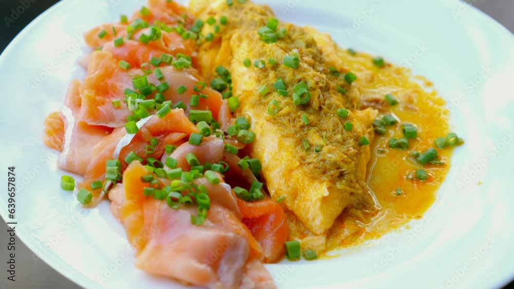 Scrambled eggs and salmon on a plate. Tasty breakfast dish with healthy garnish. Hotel breakfast cuisine. Scrambled eggs and salmon on a plate. Tasty breakfast dish with healthy garnish. Hotel breakfast cuisine.