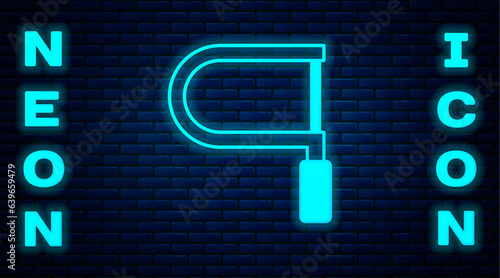 Glowing neon Hacksaw icon isolated on brick wall background. Metal saw for wood and metal. Vector