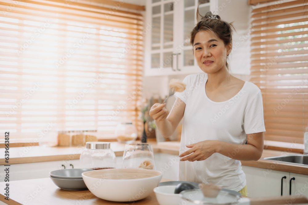 Asian wife cooking and prepare noodle meal for husband in the kitchen. Asian wife cooking and prepare noodle meal for husband in the kitchen.