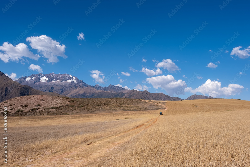 Landscapes of the Andes near the Maras Salt Flats in Peru with a green campervan driving on a dirt road Landscapes of the Andes near the Maras Salt Flats in Peru with a green campervan driving on a dirt road