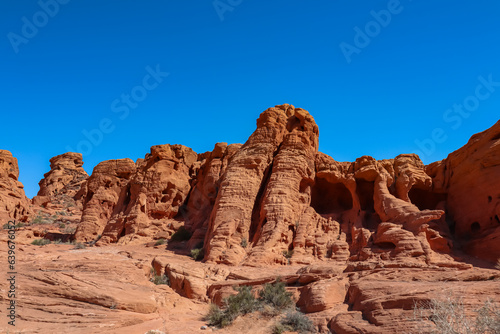 Scenic view of red rock sandstone formation in the Valley of Fire State Park, Nevada, USA. Aztec Sandstone, which formed from shifting sand dunes. Road trip in summer on a hot sunny day with blue sky