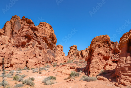 Scenic view of red rock sandstone formation in the Valley of Fire State Park, Nevada, USA. Aztec Sandstone, which formed from shifting sand dunes. Road trip in summer on a hot sunny day with blue sky