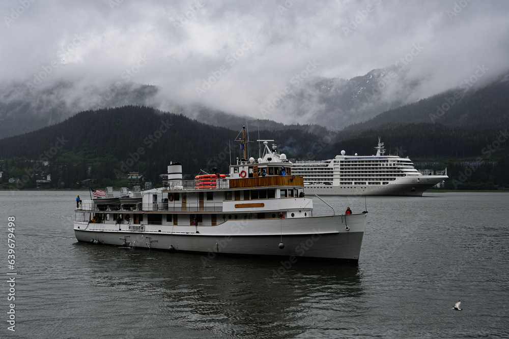 Luxury Silver cruiseship cruise ship liner Muse arrival into port of Juneau, Alaska during nature adventure Last Frontier cruising with dramatic panoramic landscape vacation