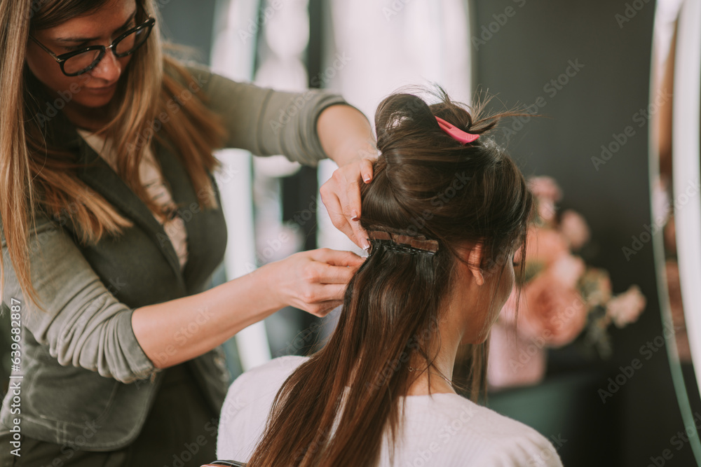 Hairstylist tying up clients hair. Hairstylist tying up clients hair.