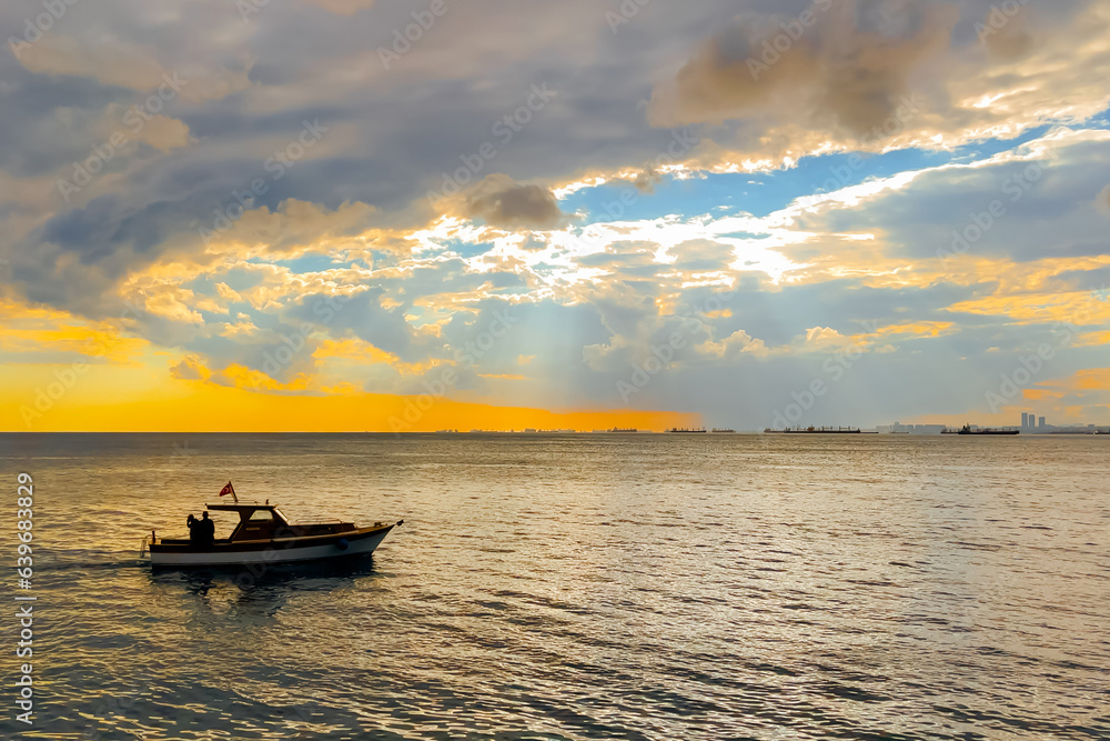 The amazing dramatic sunset sky with clouds over the Sea of Marmara surface in the evening in Turkey. Speed boats, motor boats are sailing. Cloudscape, nature and summer concept