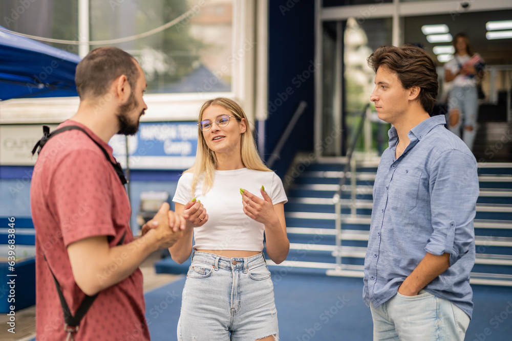 Beautiful male and female students having a conversation with their professor during break at school Beautiful male and female students having a conversation with their professor during break at school