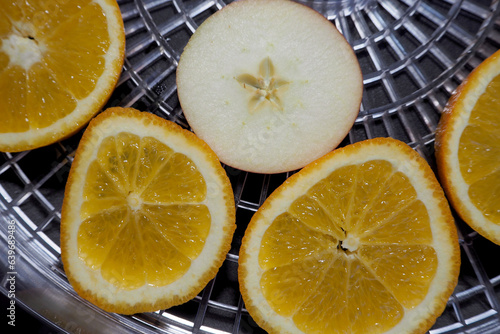 kawałki pomarańczowych jabłek leżą na plastikowej palecie suszarki do owoców. widok z góry