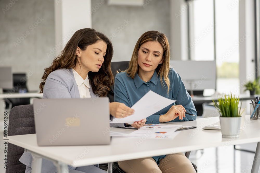 Business women working together on computer in modern office Business women working together on computer in modern office