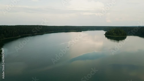 A lone boat floats on the smooth surface of the lake