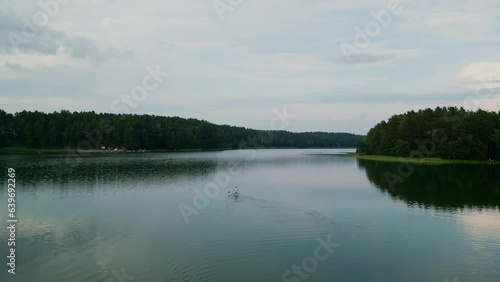 A man on a SUP floats on the surface of a lake