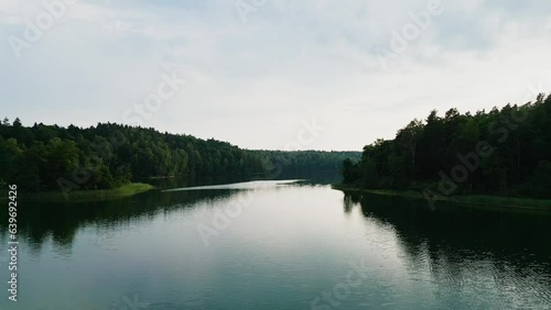 The camera moves across the surface of a lake in the middle of a forest