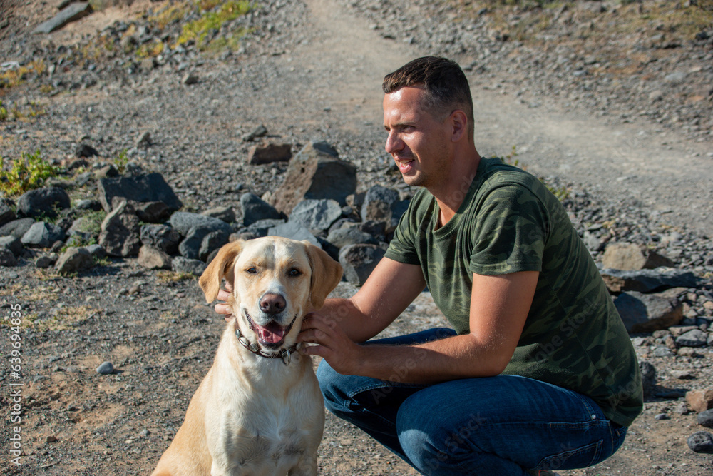 Labrador dog looks at the camera as his trainer strokes him following the good work done. Labrador dog looks at the camera as his trainer strokes him following the good work done.