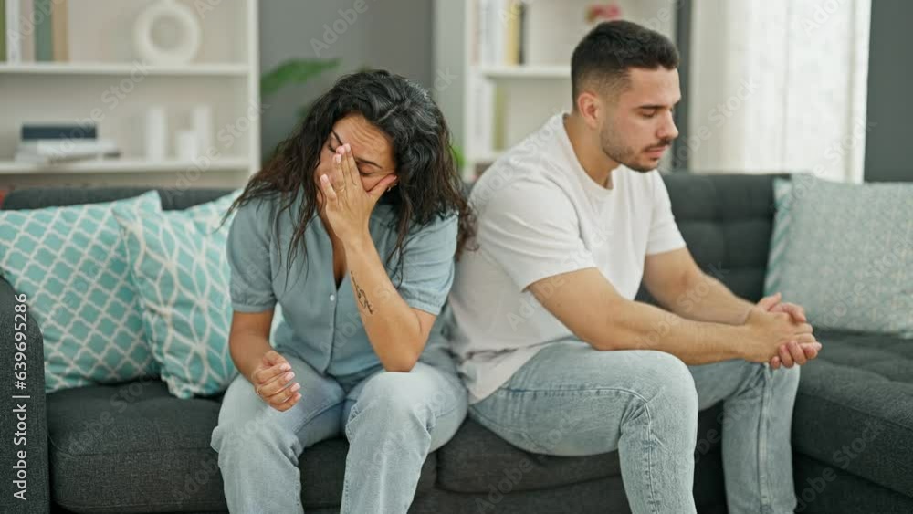 Man and woman couple sitting on sofa arguing stressed at home Man and woman couple sitting on sofa arguing stressed at home