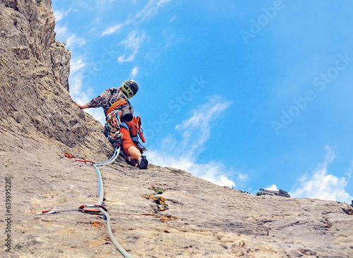 Young woman climbing in the Dolomits  Italy. The rock-climber during rock conquest