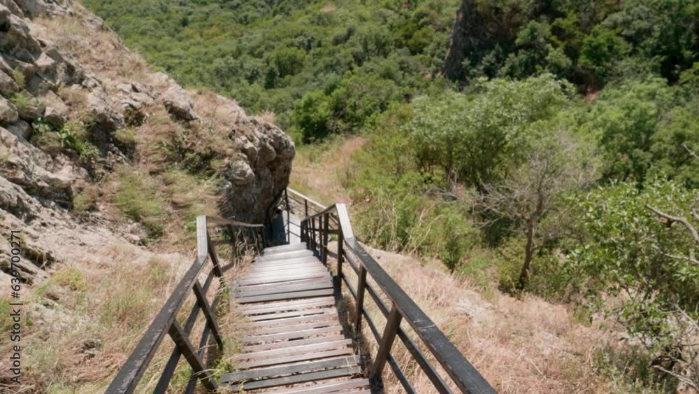 first-person view, descending the narrow iron stairs in the mountains, bright sunny summer day first-person view, descending the narrow iron stairs in the mountains, bright sunny summer day