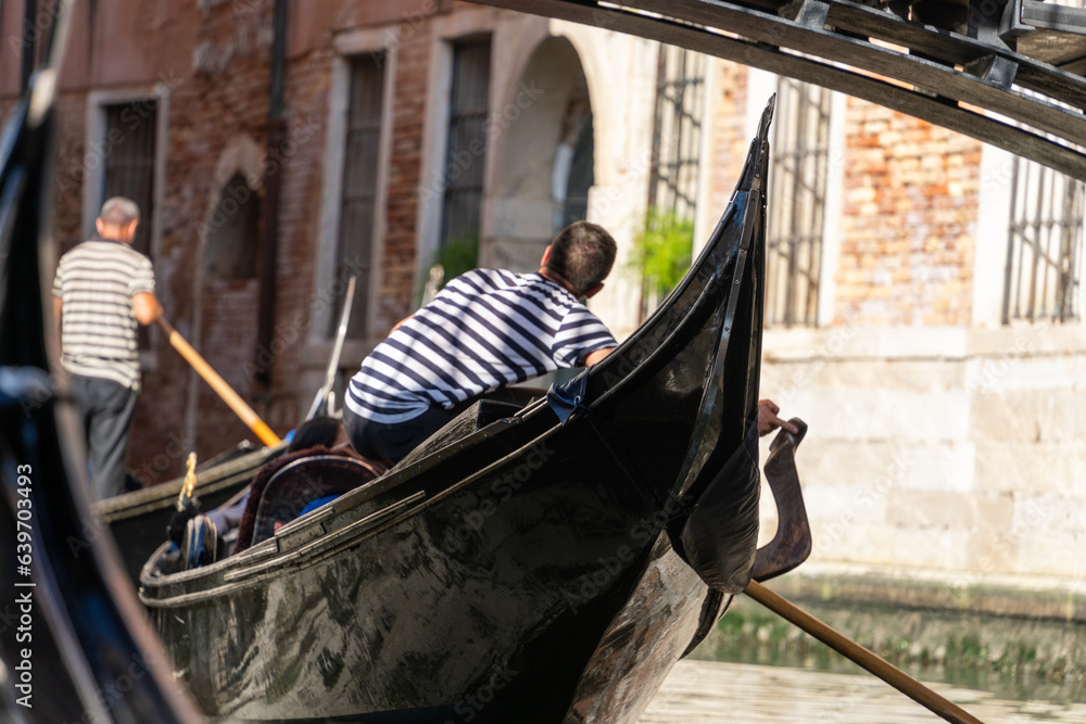 Venetian gondola with gondoliere, under the bridge.