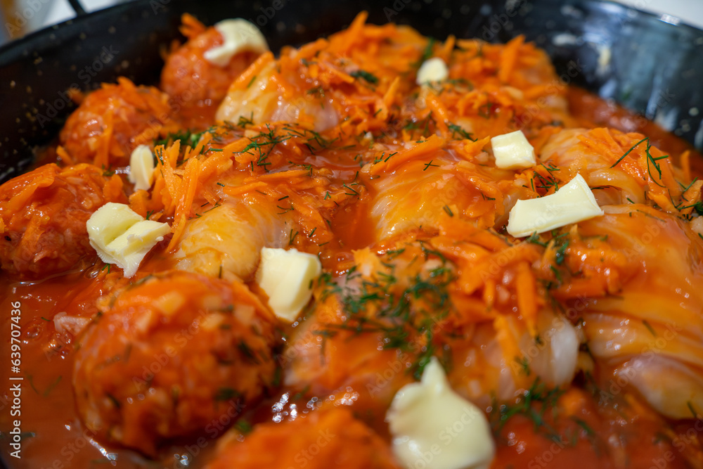 Traditional Ukrainian raw (unprepared) stuffed cabbage rolls with meat, rice and carrot in iron cauldron Traditional Ukrainian raw (unprepared) stuffed cabbage rolls with meat, rice and carrot in iron cauldron