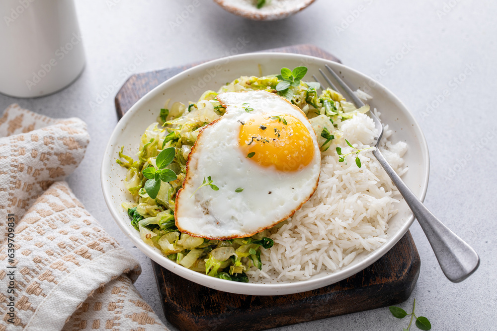 Rice bowl with sauteed cabbage and fried egg, healthy lunch or breakfast idea Rice bowl with sauteed cabbage and fried egg, healthy lunch or breakfast idea