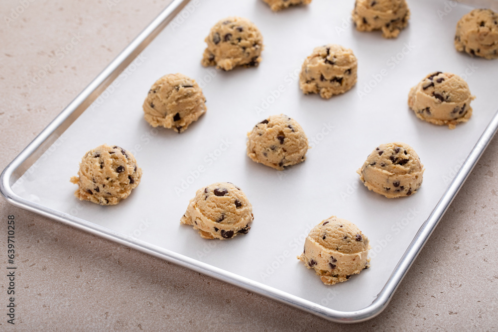 © fahrwasser - Chocolate chip cookie dough scoopes on a cookie sheet ready to be baked