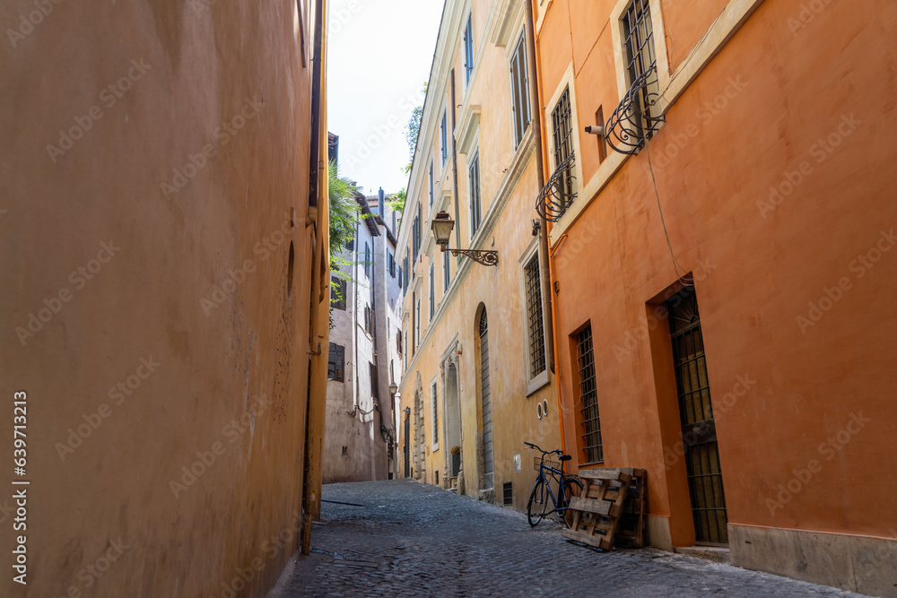 Bike leans against terracotta wall on Roman street in the Ponte area of Rome, Italy on summers day - Landscape 