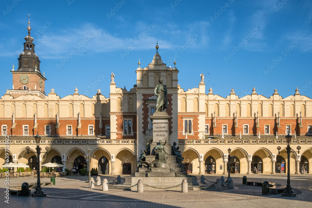 Obraz premium Statue of Adam Mickiewicz and Sukiennice buidning in Cracow, Poland