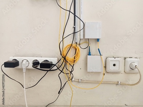 Electric and fiber optic cable messy and roughly on the wall, bad cable management at home internet and tv