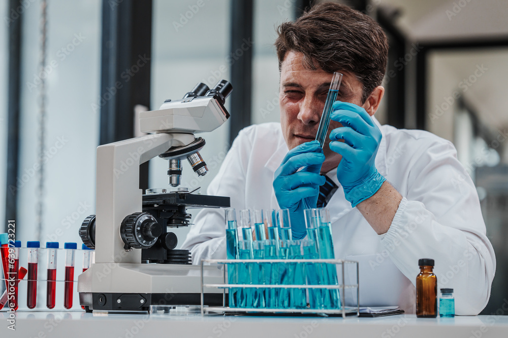 Chemologist explains examining blood in test tube. Examples of drugs