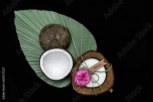 Świeczka ekologiczna zapachowa kokos z różą na zielonym liściu na czarbym tle