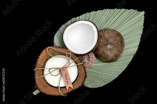 Świeczka ekologiczna zapachowa kokos na zielonym liściu na czarnym tle