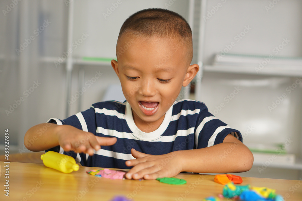 Boy making plasticine to promote development on the table in the house. Boy making plasticine to promote development on the table in the house.