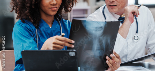 Medical staff team african american meeting discussing chest x-ray film Radiologists medical doctors that specialize in diagnosing, treating injuries, diseases, radiology, procedures exams, tests