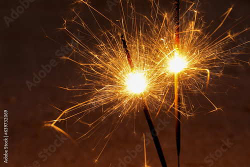 Close up of Sparkler on beach. Burning sticks of Bengal fire  Sparks of bright bengal lights burning on the beach.