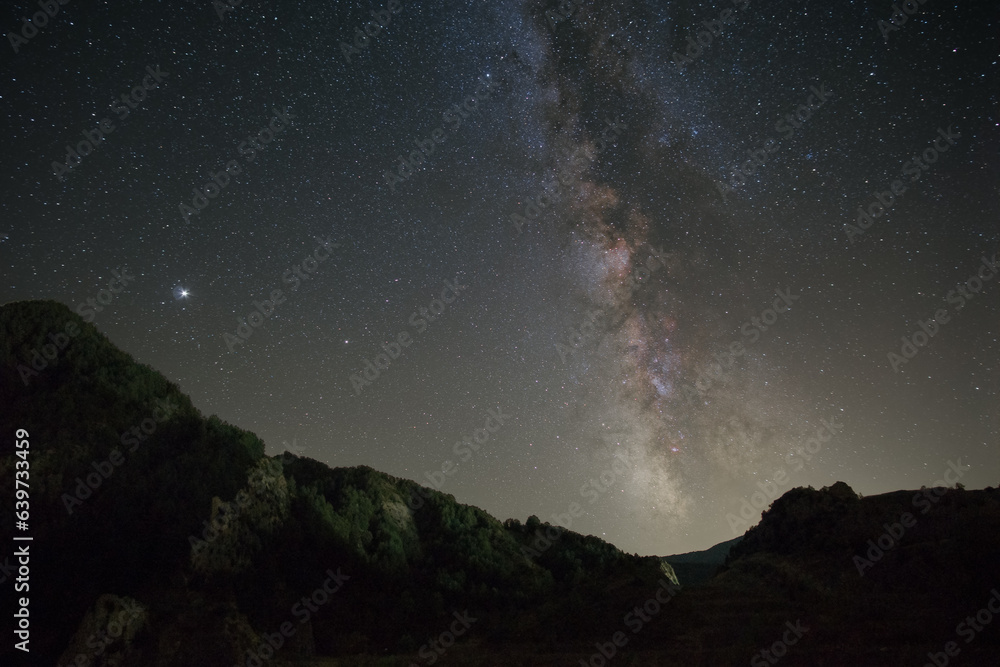 Night landscape in the Pyrenees mountains with Milky Way and planet Jupiter above, Janovas, Aragon, Huesca, Spain