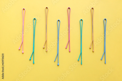 Top view of colorful pastel color hair clips on yellow background. modern accessories for hair, accessories and hairstyles concept, luxury color