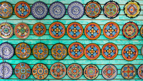 Rows of Mexican traditional colorful crockery crafts up for sale at store.