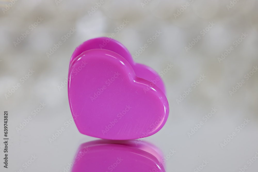 Fototapeta premium Pink Heart shaped clip close up view with reflection shallow depth of field.